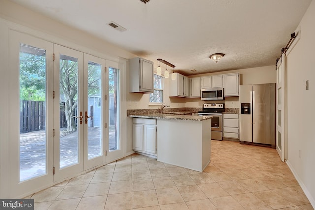 8838 Cross Country Pl, Gaithersburg, MD 20879 - kitchen with appliances with stainless steel finishes, a peninsula, a sink, light tile patterned flooring, and dark stone counters
