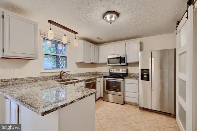 8838 Cross Country Pl, Gaithersburg, MD 20879 - kitchen with appliances with stainless steel finishes, a sink, a peninsula, light stone counters, and white cabinets