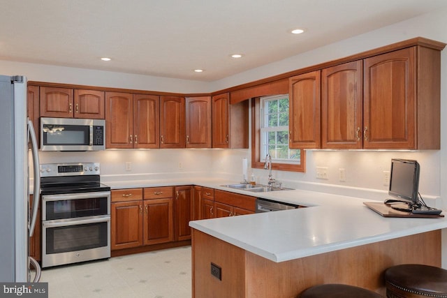2799 Greenway Ct, Rockingham, VA 22802 - kitchen with stainless steel appliances, a peninsula, brown cabinets, a sink, and a breakfast bar