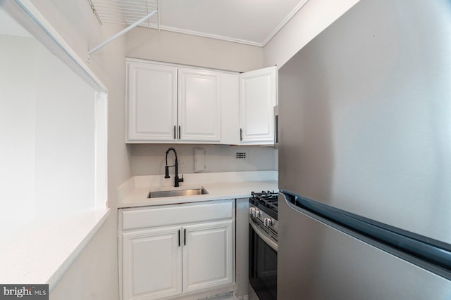 922 24th St NW Unit 806, Washington, DC 20037 - kitchen with stainless steel appliances, a sink, white cabinets, light countertops, and crown molding