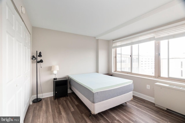 922 24th St NW Unit 806, Washington, DC 20037 - bedroom with baseboards, dark wood-style flooring, radiator, and a closet
