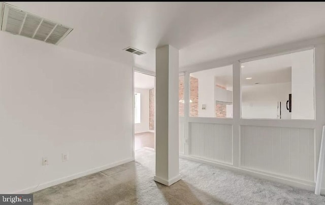 empty room with light colored carpet and baseboards