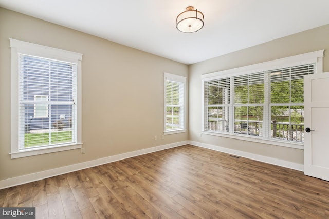 empty room featuring baseboards and wood finished floors