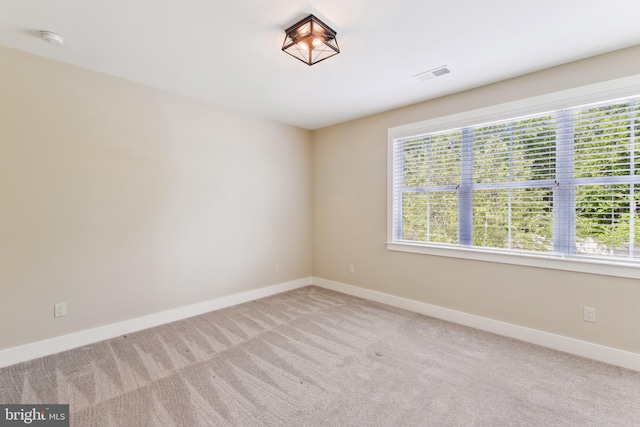 carpeted empty room with baseboards and a smoke detector