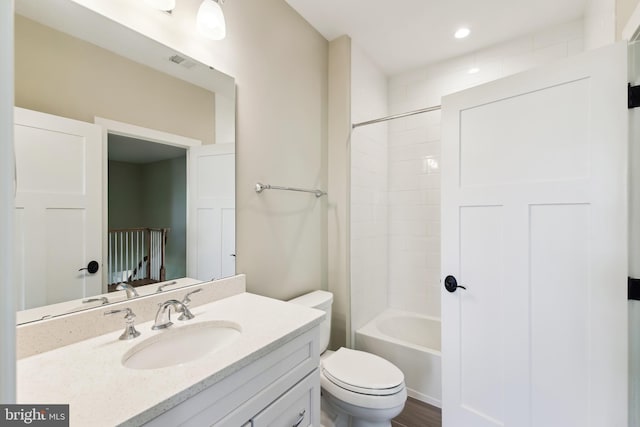 bathroom with toilet, vanity,  shower combination, and recessed lighting