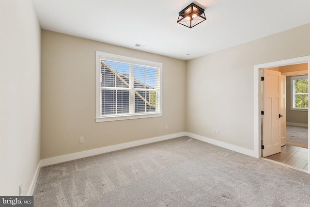 carpeted spare room with baseboards