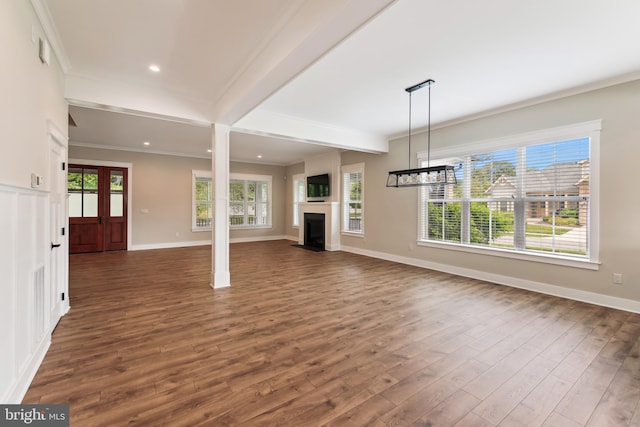 unfurnished living room with dark wood-style floors, a fireplace with flush hearth, ornamental molding, baseboards, and beamed ceiling