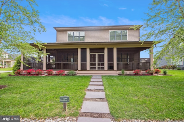 view of front of property with a sunroom and a front lawn