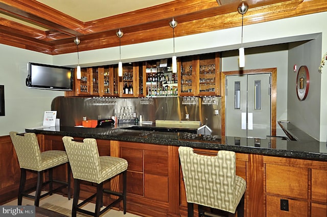 indoor wet bar with high quality fridge and hanging light fixtures