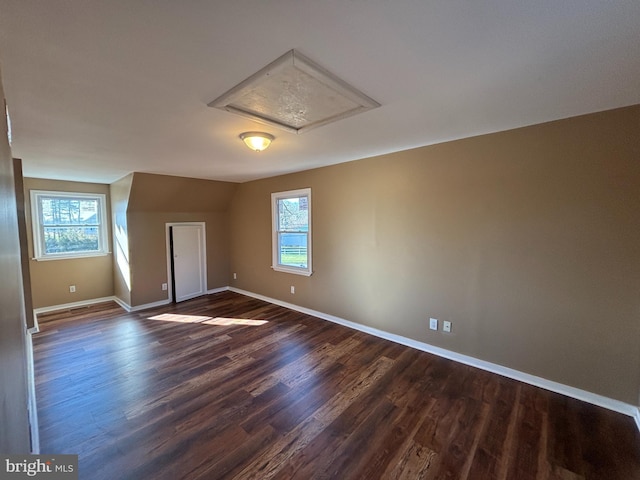 bonus room with healthy amount of natural light and dark wood-type flooring
