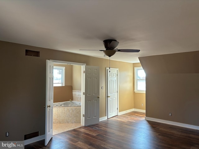 spare room featuring dark wood-type flooring, ceiling fan, and baseboards