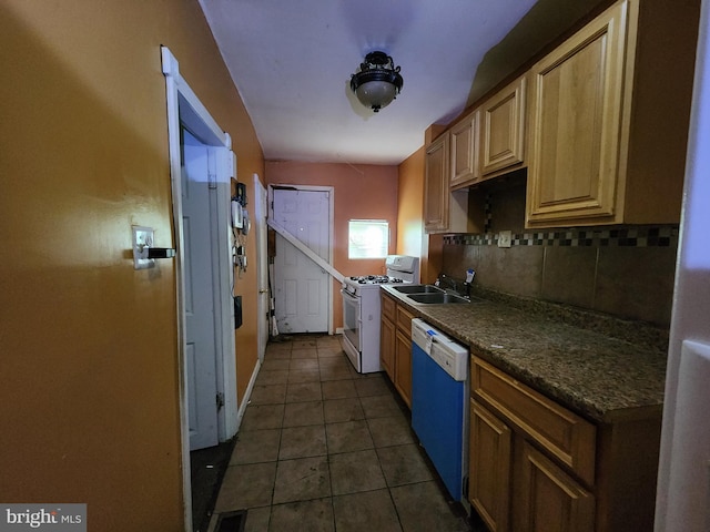 kitchen featuring dishwashing machine, white gas range oven, a sink, dark countertops, and tasteful backsplash