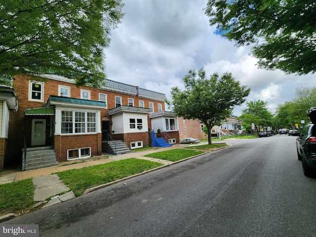 view of asphalt road featuring curbs and sidewalks