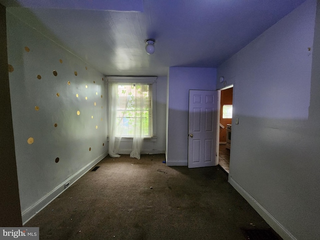unfurnished bedroom with baseboards and carpet