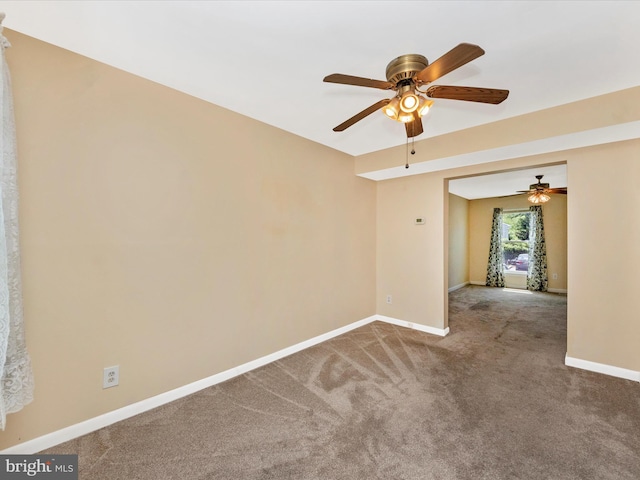 spare room with carpet flooring, a ceiling fan, and baseboards
