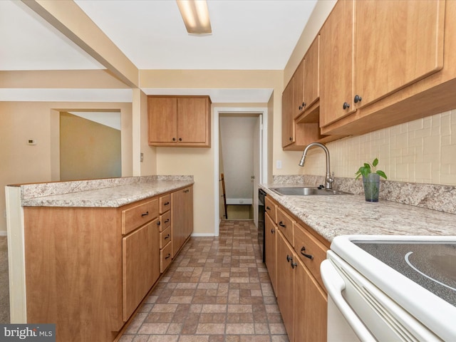 kitchen with a sink, light countertops, backsplash, baseboards, and a peninsula