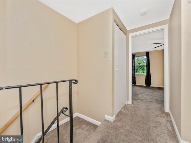 hall with light colored carpet and baseboards