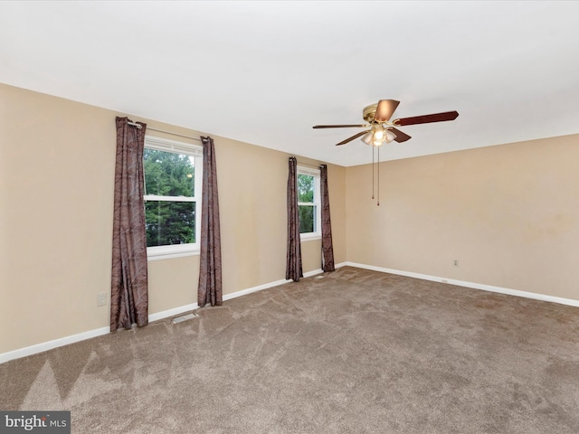 unfurnished room featuring a ceiling fan, carpet, and baseboards