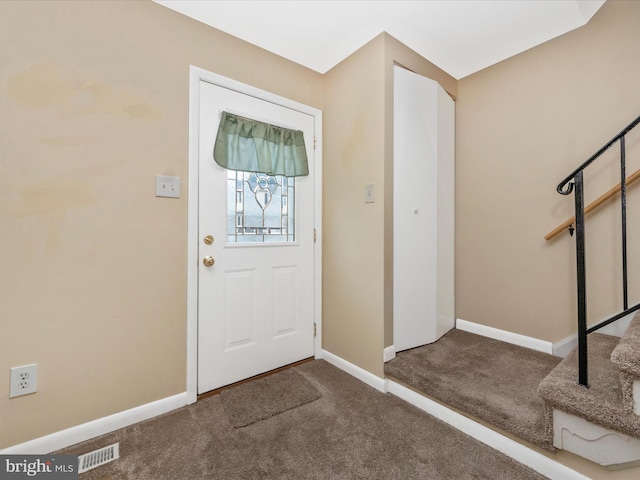 foyer entrance featuring carpet floors and baseboards