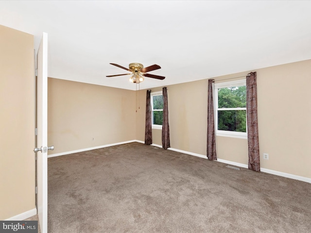 empty room featuring a ceiling fan, carpet flooring, and baseboards