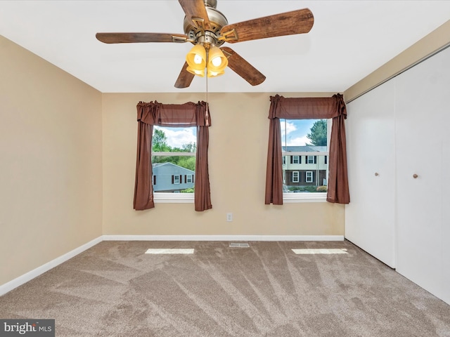 unfurnished bedroom with multiple windows, carpet floors, and baseboards