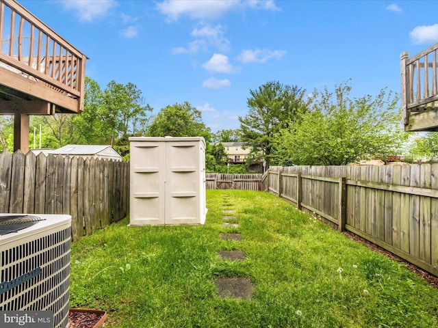 view of yard with a storage shed, central AC, and an outbuilding