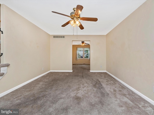 carpeted empty room with ceiling fan and baseboards