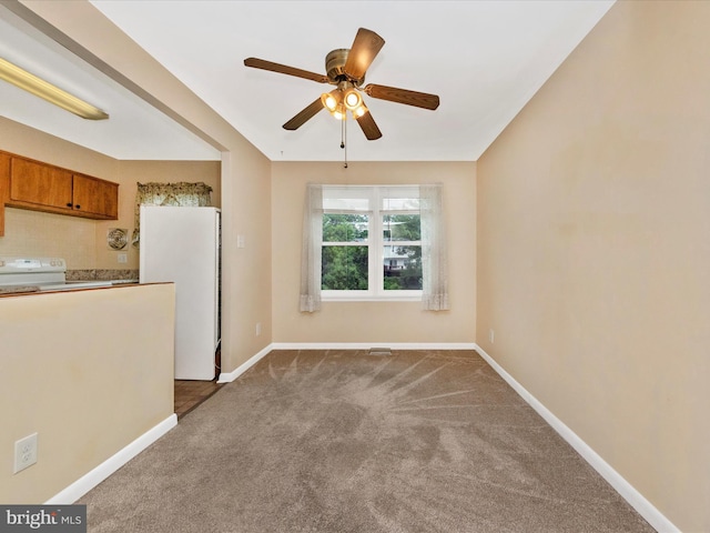 unfurnished room with dark carpet, a ceiling fan, and baseboards