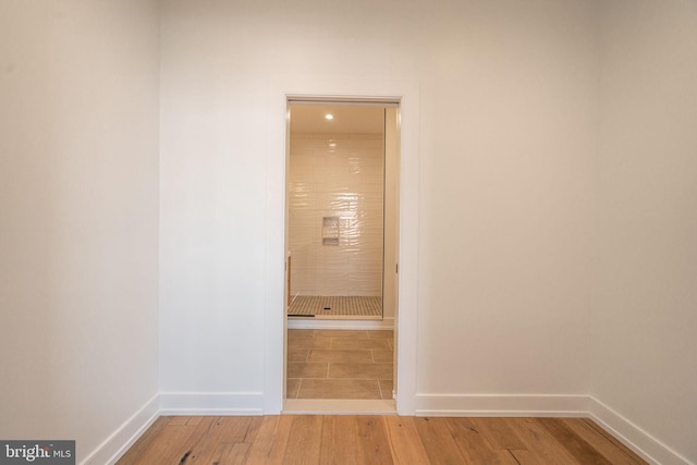 hallway with light wood-style flooring and baseboards