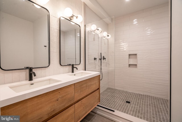 full bathroom with double vanity, tiled shower, and tile patterned flooring