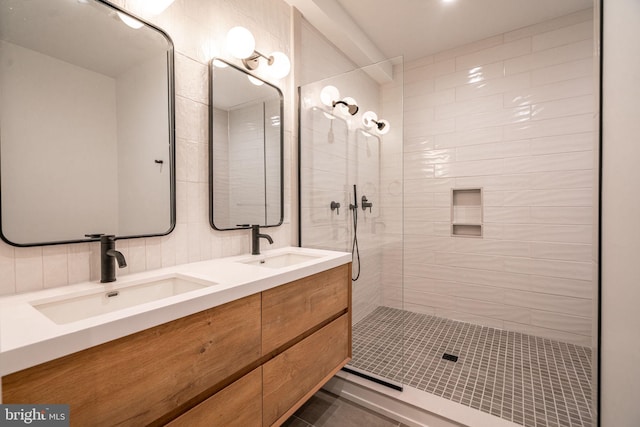 full bathroom featuring a tile shower, double vanity, and tile patterned flooring