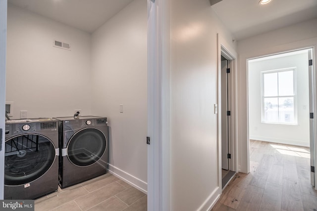 laundry area with washing machine and clothes dryer, baseboards, recessed lighting, and wood finished floors