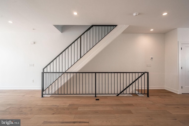 staircase with recessed lighting, wood finished floors, and baseboards