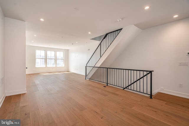 spare room featuring wood finished floors, baseboards, and recessed lighting