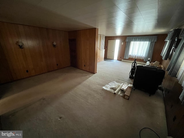 additional living space featuring light colored carpet, wooden walls, and a baseboard radiator