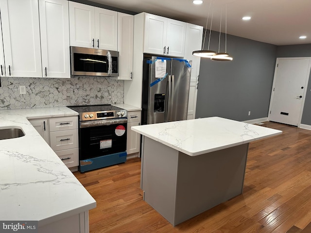 124 E Ruscomb St, Philadelphia, PA 19120 - kitchen featuring appliances with stainless steel finishes, light wood-type flooring, backsplash, white cabinets, and recessed lighting