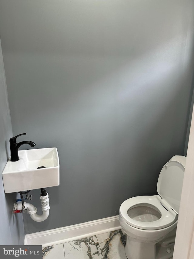 124 E Ruscomb St, Philadelphia, PA 19120 - bathroom with marble finish floors, toilet, baseboards, and a sink