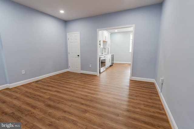 3211 Baker St, Baltimore, MD 21216 - unfurnished bedroom with dark wood-type flooring, baseboards, recessed lighting, and a sink