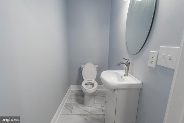 3211 Baker St, Baltimore, MD 21216 - bathroom with marble look tiles, toilet, vanity, and baseboards