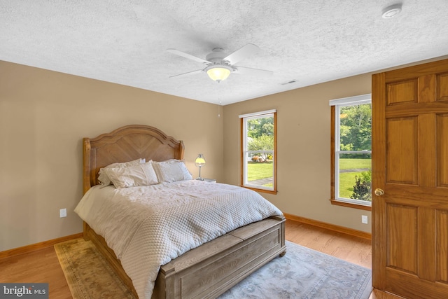 10150 Lapworth Pl, Charlotte Hall, MD 20622 - bedroom featuring baseboards, light wood finished floors, a textured ceiling, and ceiling fan