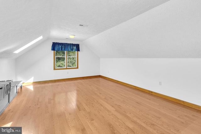 10150 Lapworth Pl, Charlotte Hall, MD 20622 - bonus room featuring a textured ceiling, light wood-style flooring, vaulted ceiling, and baseboards