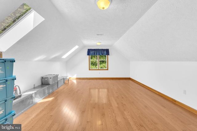 10150 Lapworth Pl, Charlotte Hall, MD 20622 - bonus room featuring a skylight, light wood-style flooring, a textured ceiling, vaulted ceiling, and baseboards