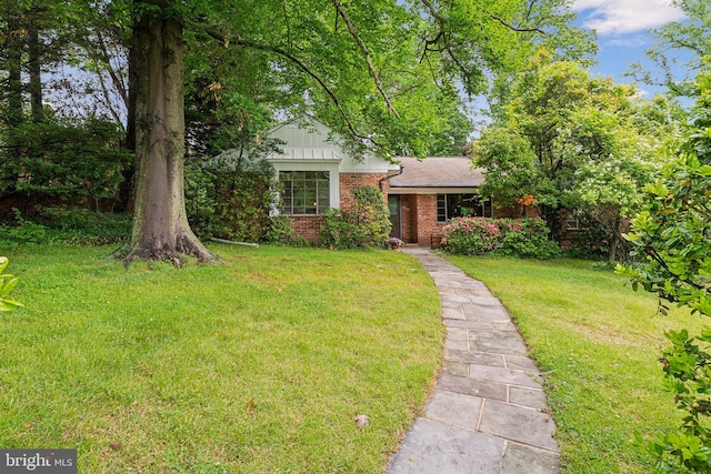 view of front of house with brick siding and a front lawn