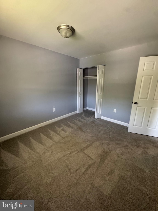 6708 Calmos St, Capitol Heights, MD 20743 - unfurnished bedroom featuring dark colored carpet, a closet, and baseboards