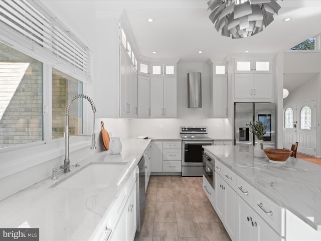 kitchen with stainless steel appliances, a sink, plenty of natural light, white cabinetry, and recessed lighting