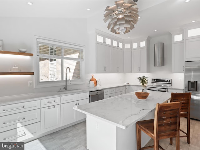 kitchen featuring appliances with stainless steel finishes, a sink, a center island, plenty of natural light, and recessed lighting