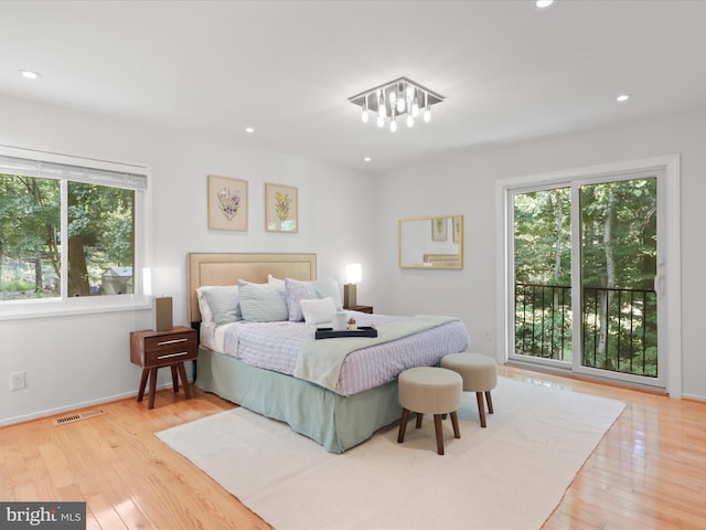 bedroom featuring multiple windows, wood finished floors, recessed lighting, a chandelier, and baseboards