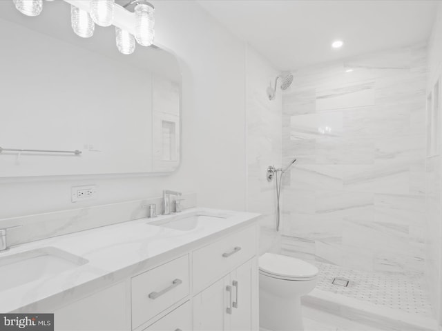 bathroom with toilet, a tile shower, double vanity, and recessed lighting