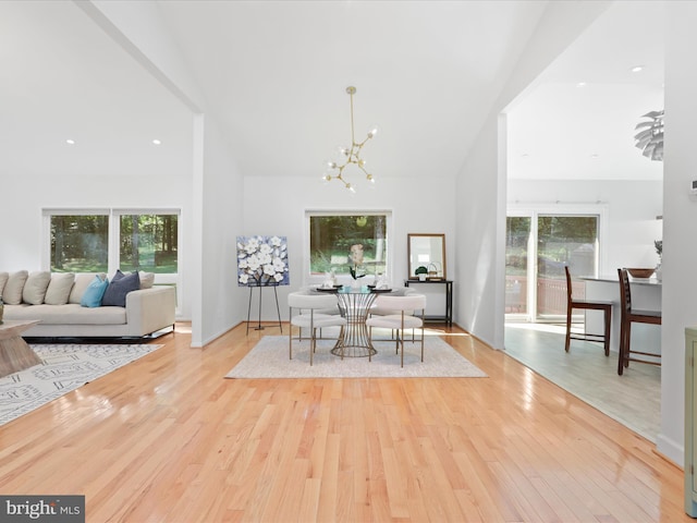 dining room with a chandelier, wood finished floors, and high vaulted ceiling