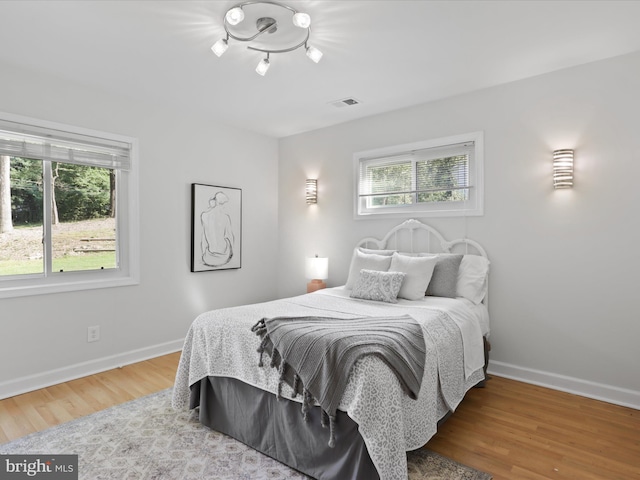 bedroom with baseboards and wood finished floors